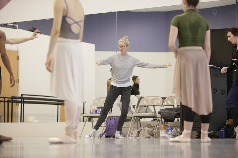 Gemma Bond demonstrates in jeans and socks in a rehearsal to dancers in leos, long tutus and pointe shoes